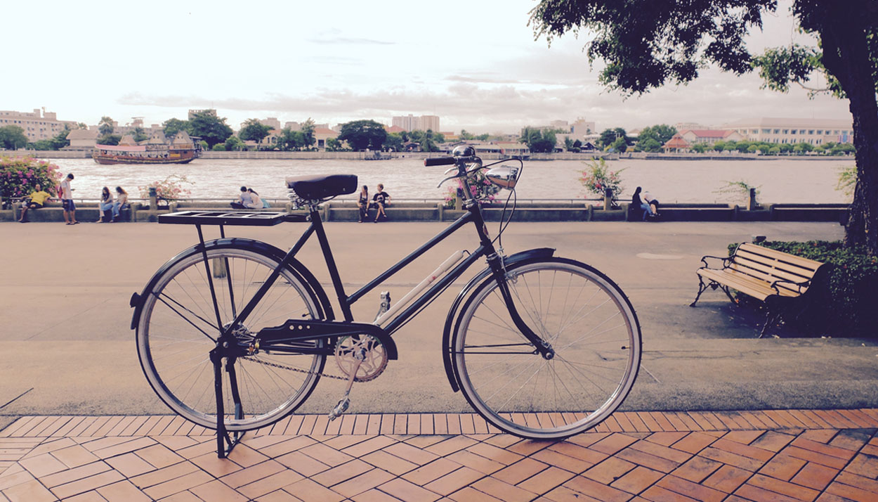 Vintage bike by the river at sunset